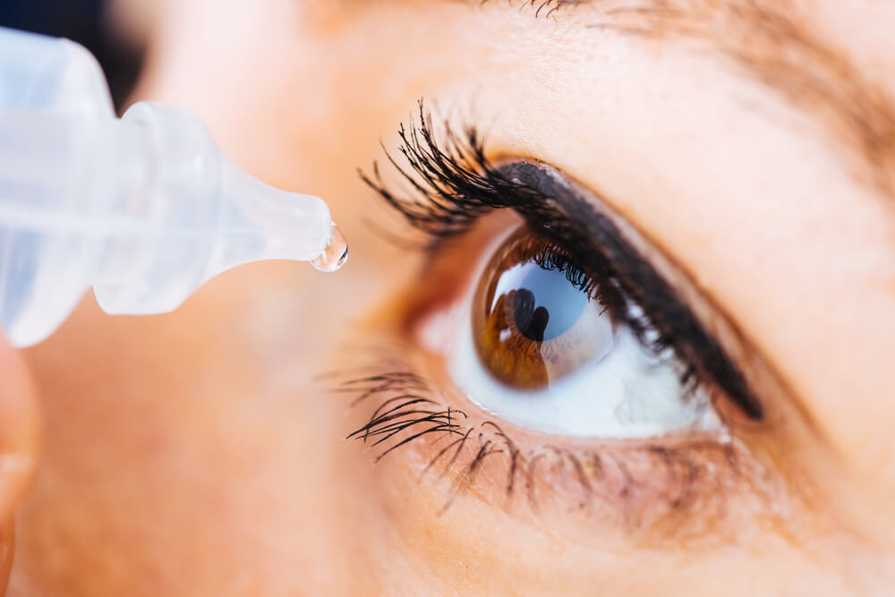 Close-up of a patient applying eye drops for dry eyes treatment at Moorfields Eye Hospital Duba