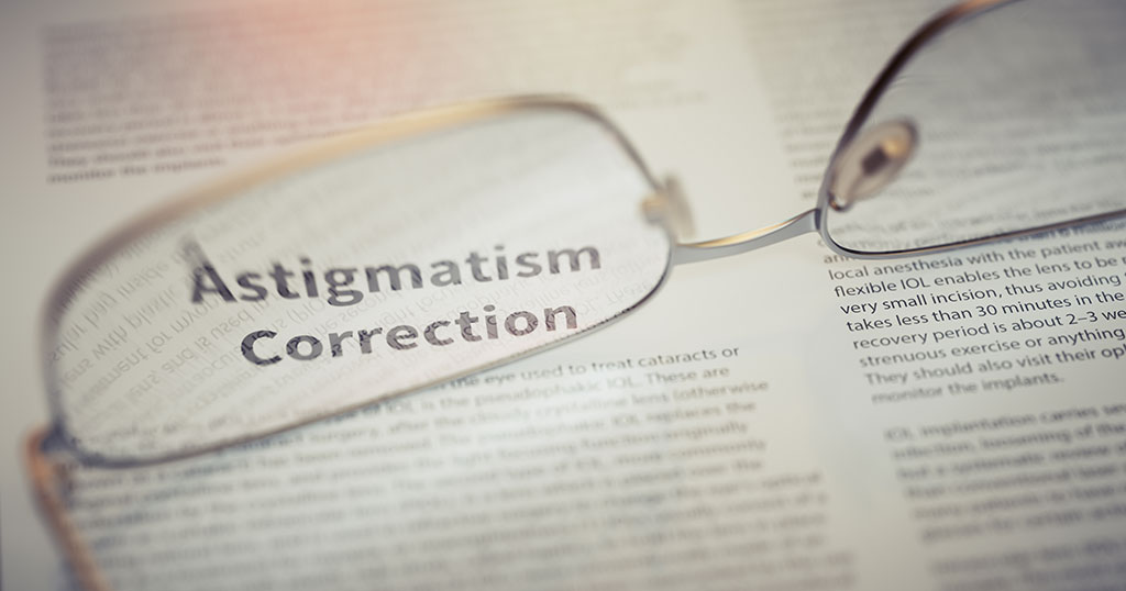 Close-up of reading glasses lying on a document, with the text “Astigmatism Correction” sharply in focus through one lens.