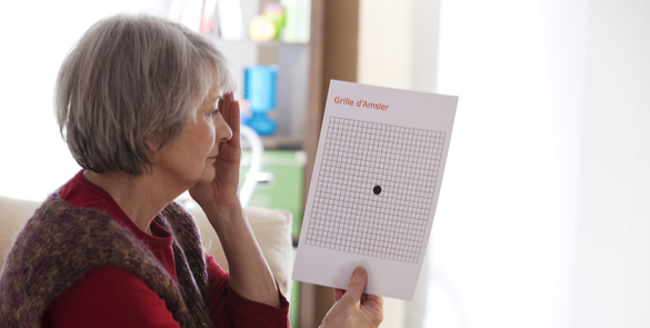 Elderly woman using an Amsler grid test to check for signs of macular degeneration or visual distortion