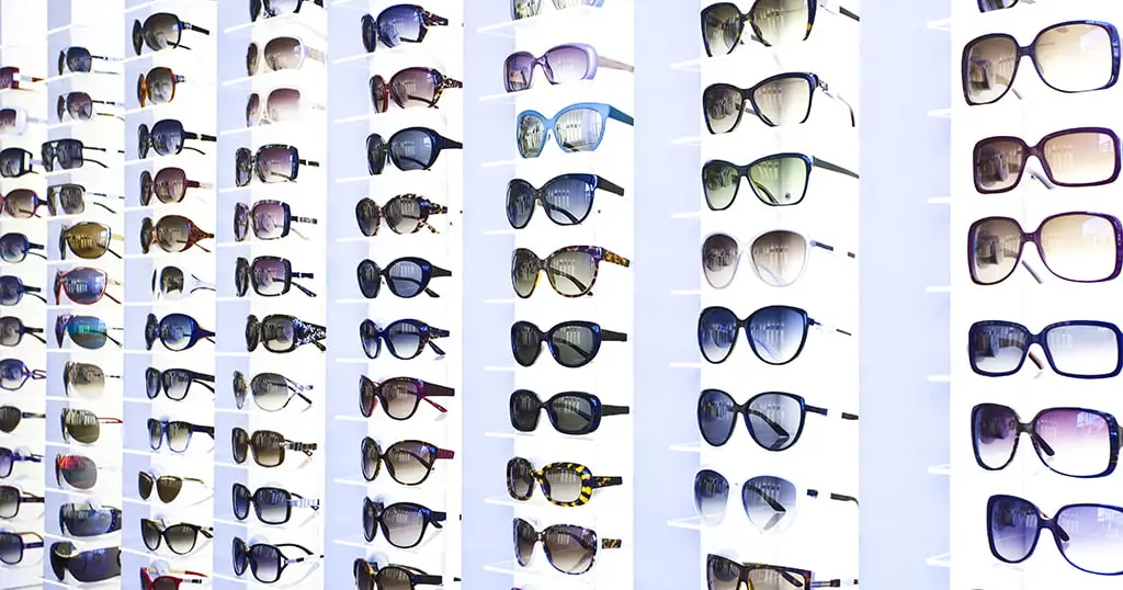 Display wall filled with various styles of sunglasses and eyeglasses in Moorfields Dubai Optical store.